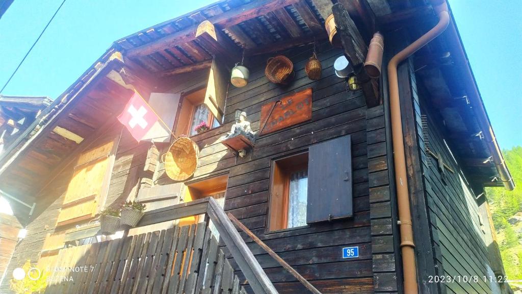 une maison en bois avec un escalier en face de celle-ci dans l'établissement Le Charlot, à Saas-Grund