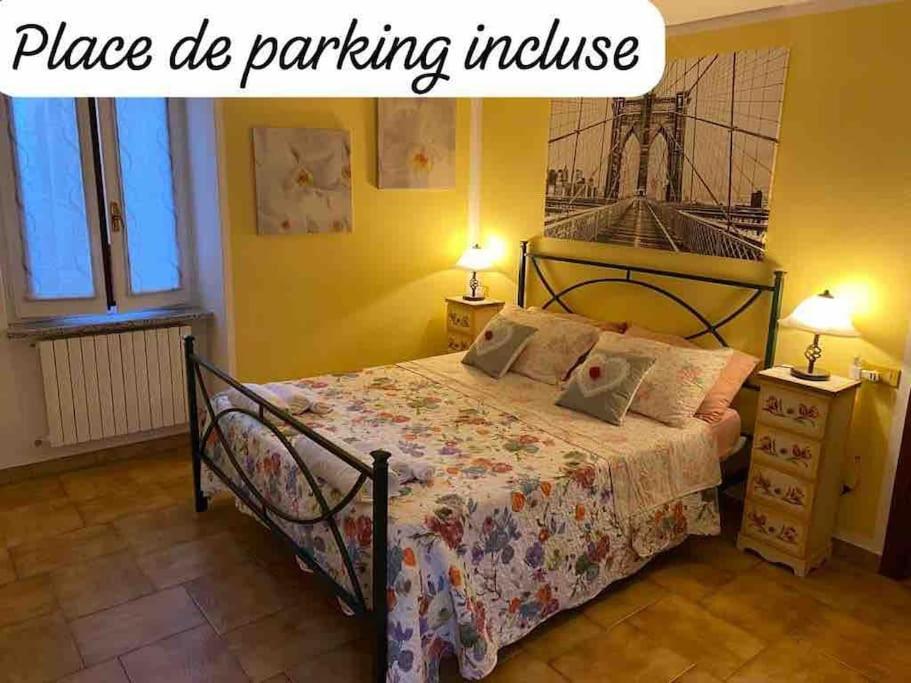 ein Schlafzimmer mit einem Bett und zwei Lampen und ein Schild, das den Parkplatz liest in der Unterkunft Ca’Lina,autentico alloggio spazioso con posto auto in Lecco