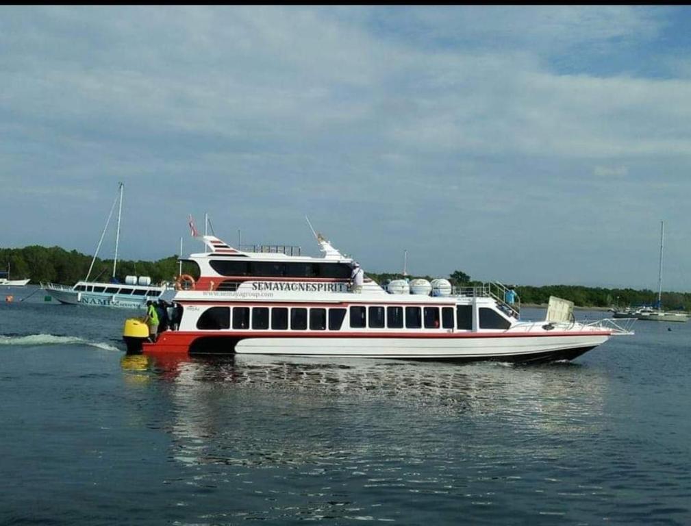 a red and white boat in the water at GiliFerries Semaya One Cruise in Padangbai