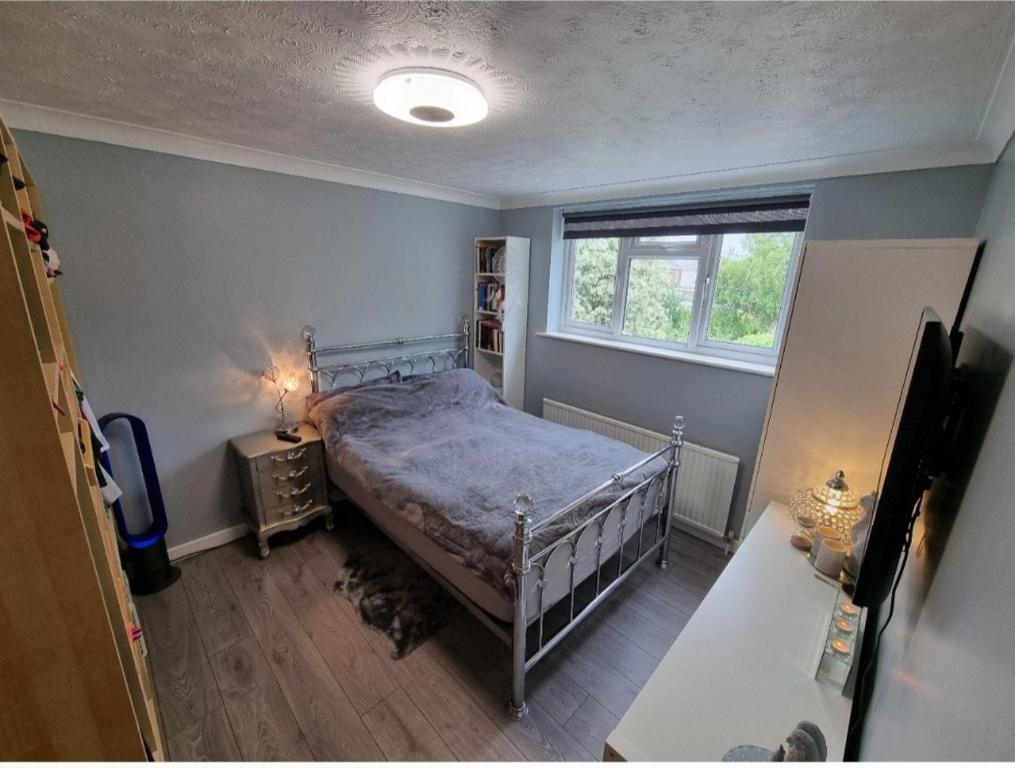 een slaapkamer met een bed en een raam bij Guest house in Longham