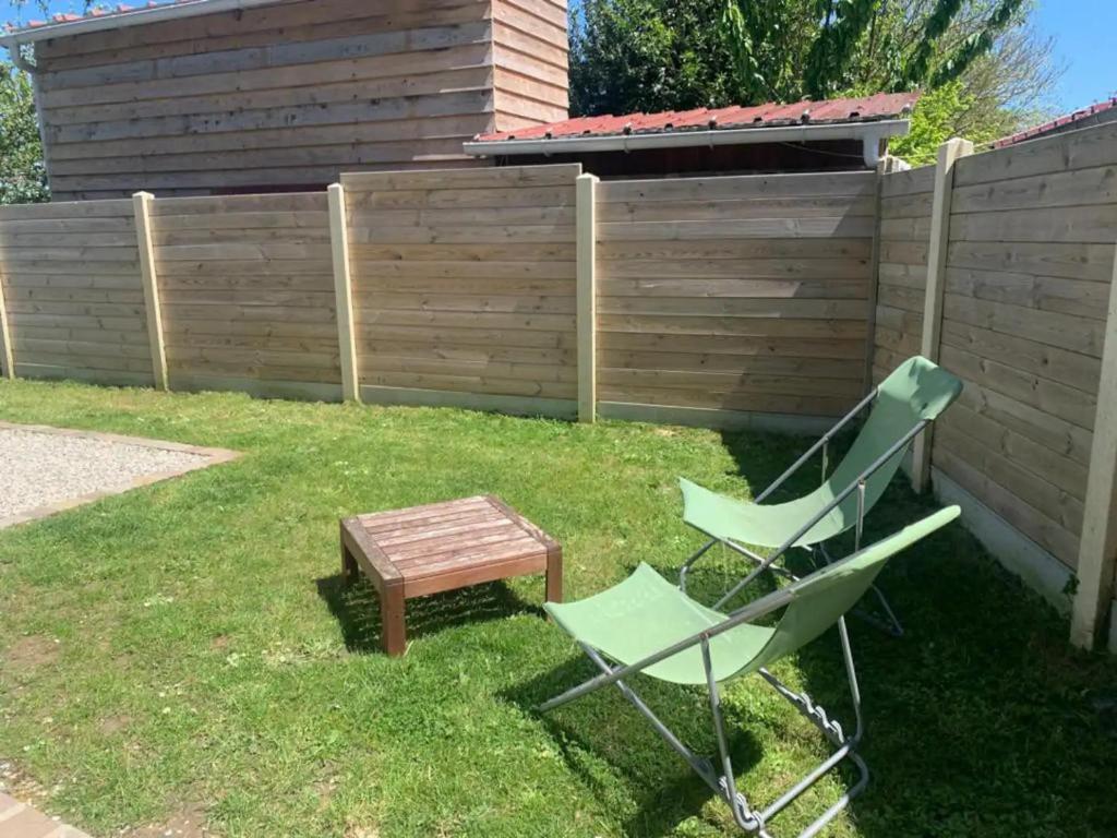 a yard with a chair and a table and a fence at Villa kahlo Omaha Beach in Colleville-sur-Mer