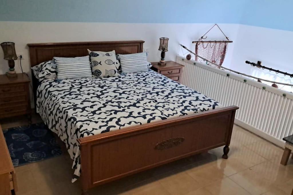 1 dormitorio con 1 cama con edredón blanco y negro en BeachHouse Ischia, en Isquia