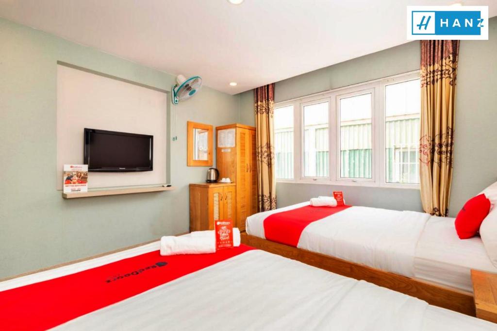 a bedroom with two beds and a flat screen tv at Luan Vu Hotel in Ho Chi Minh City