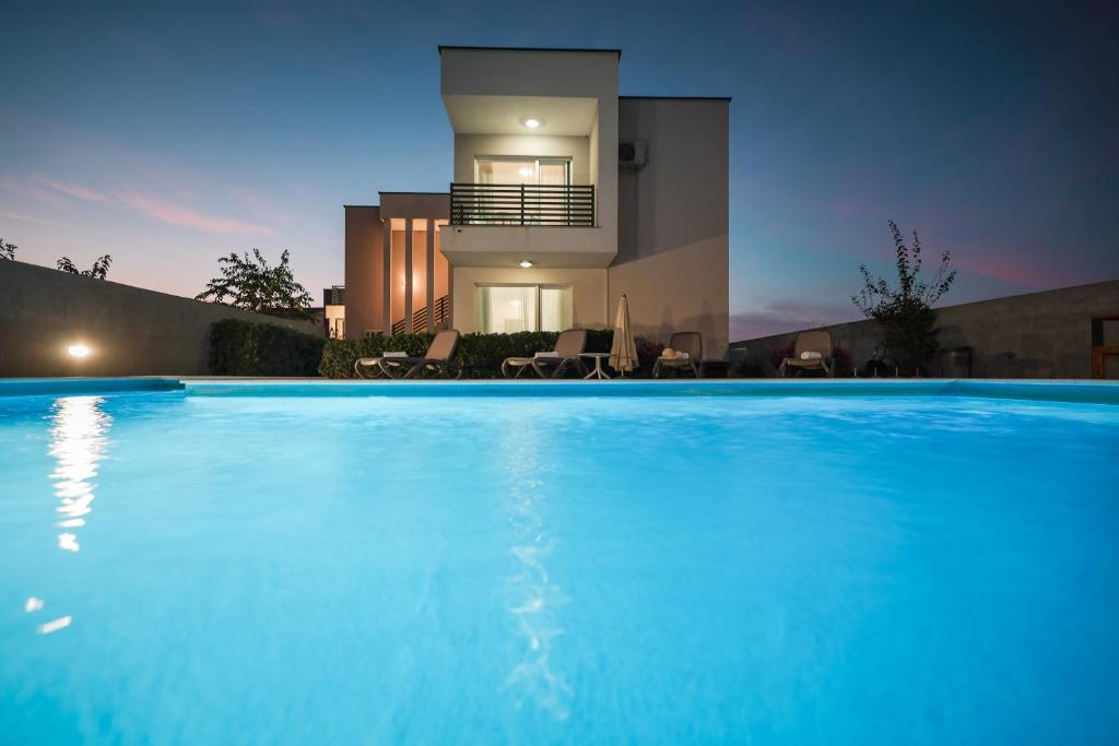 a large swimming pool in front of a house at Villa Tonći Zaton in Zaton