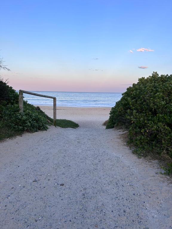 a dirt road leading to a beach with the ocean at Bluemoon Getaway in Catherine Hill Bay