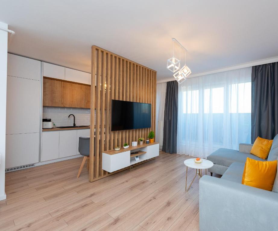ein Wohnzimmer mit einem blauen Sofa und einer Küche in der Unterkunft ART Apartment II in Târgu Mureș