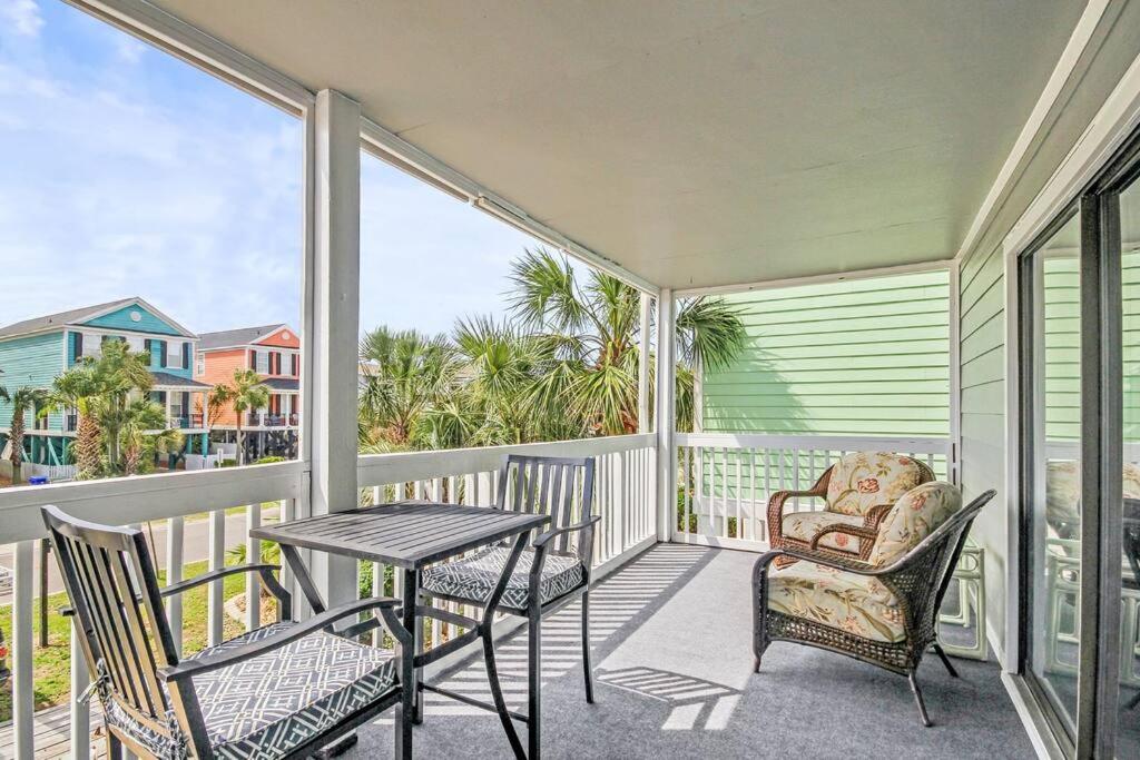 a balcony with a table and chairs and a table and chairs at 2nd Row Beach Condo, steps to the beach, with Pool in Myrtle Beach