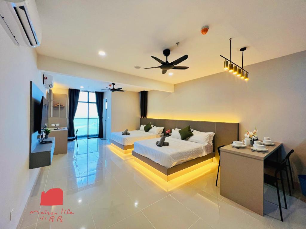a bedroom with two beds and a table in it at The Shore Maison Life 小居屋 in Kota Kinabalu