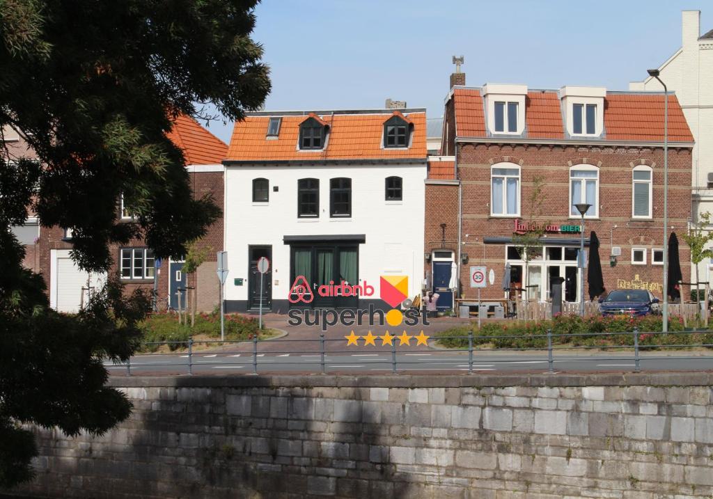 un edificio blanco con un letrero al lado de una calle en Modern Studio & Apartment Roermond en Roermond