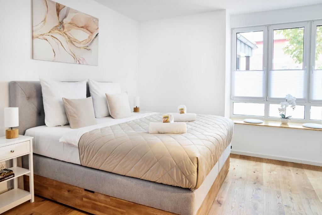 a white bedroom with a large bed with white pillows at Ajko Homes - Loft-Apartment mit Parkplatz bei Heidelberg in Dossenheim