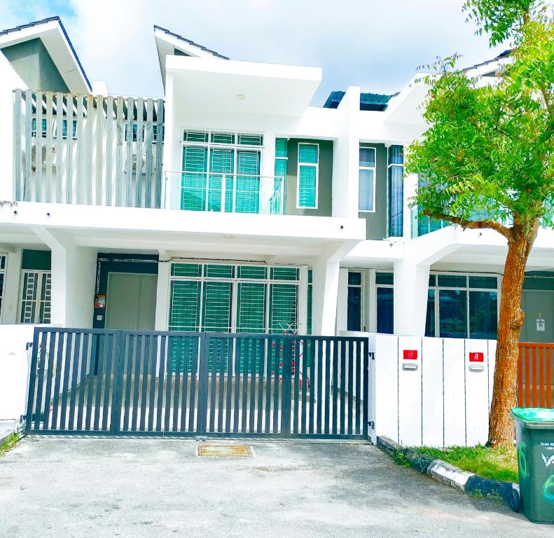 a white house with a gate and a tree at langkawi homestay murah empat bilik in Kuah