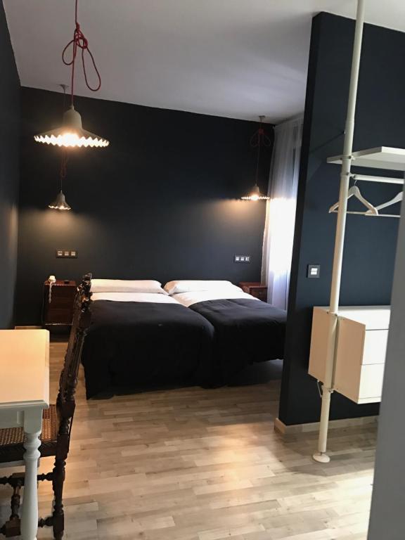 a bedroom with a bed and a black wall at Hostal San Francisco in Cuéllar