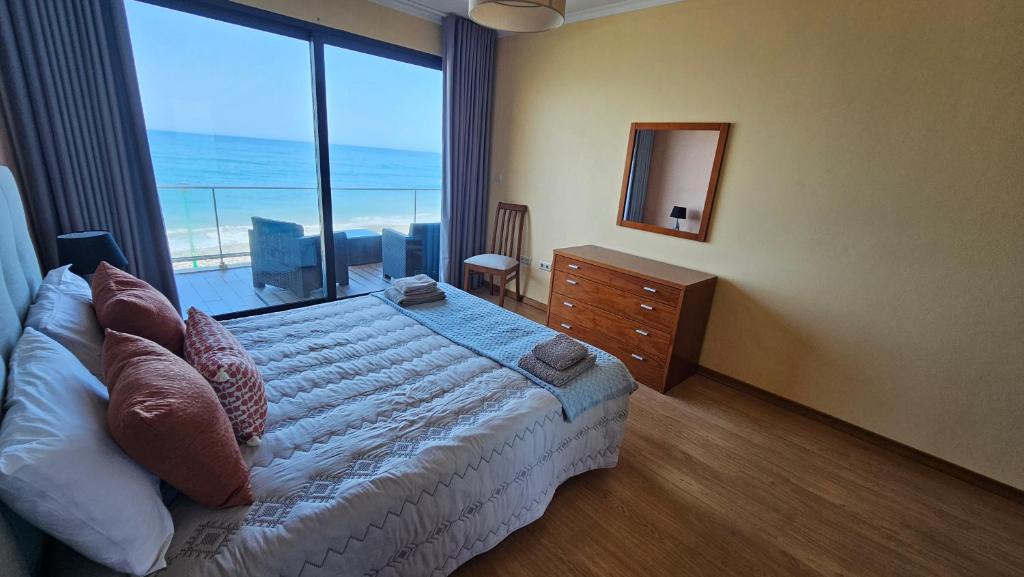 a bedroom with a bed and a large window at Ocean Breeze Apartment in São Vicente