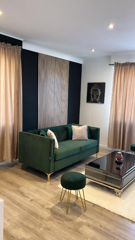 a living room with a green couch and a table at Maison jardin paisible 1 chambre in Mérignac