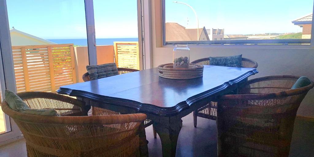 a dining room table and chairs with a view of the ocean at Secrets 2 at Waterkant 7 in Jeffreys Bay