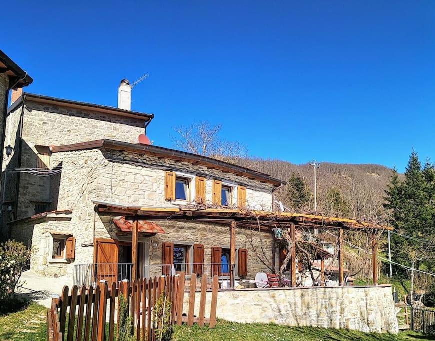 an old stone house with a fence in front of it at The house in the paradise of Serra. in Chiusi della Verna