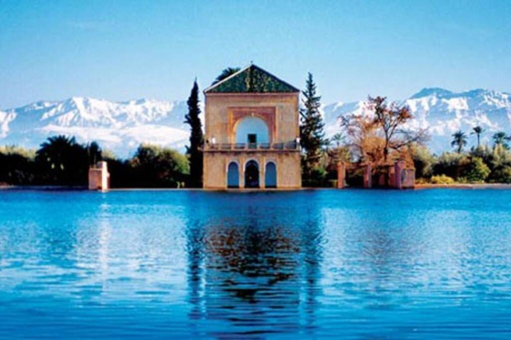 um edifício no meio de um lago com montanhas cobertas de neve em Stylish Art Deco 2/2 - Best Location in Marrakech! em Marrakech