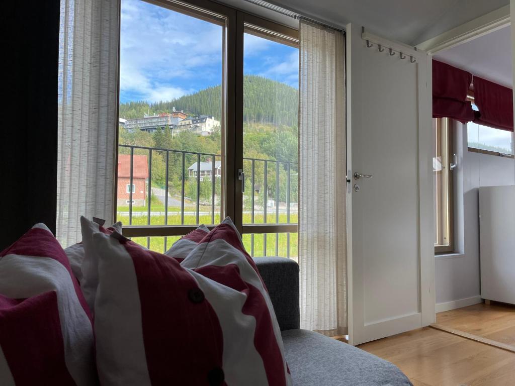 a living room with a couch and a large window at Åre Travel - Mörviksgården in Åre
