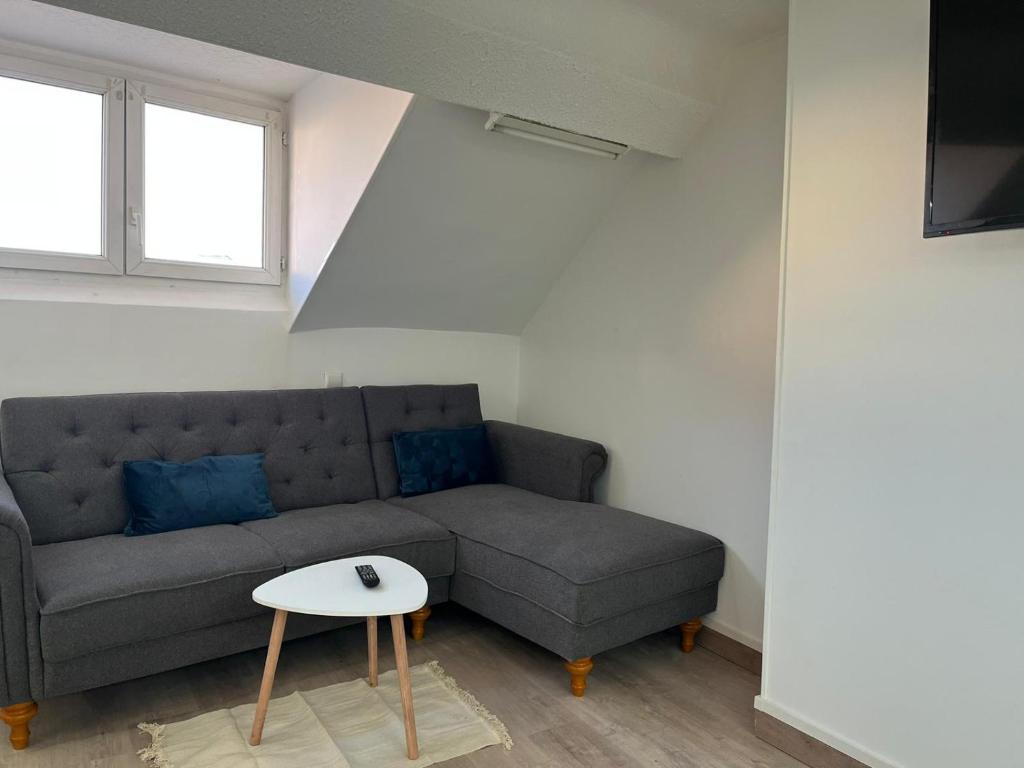 a living room with a couch and a table at Superbe appartement refait à neuf in Montlhéry