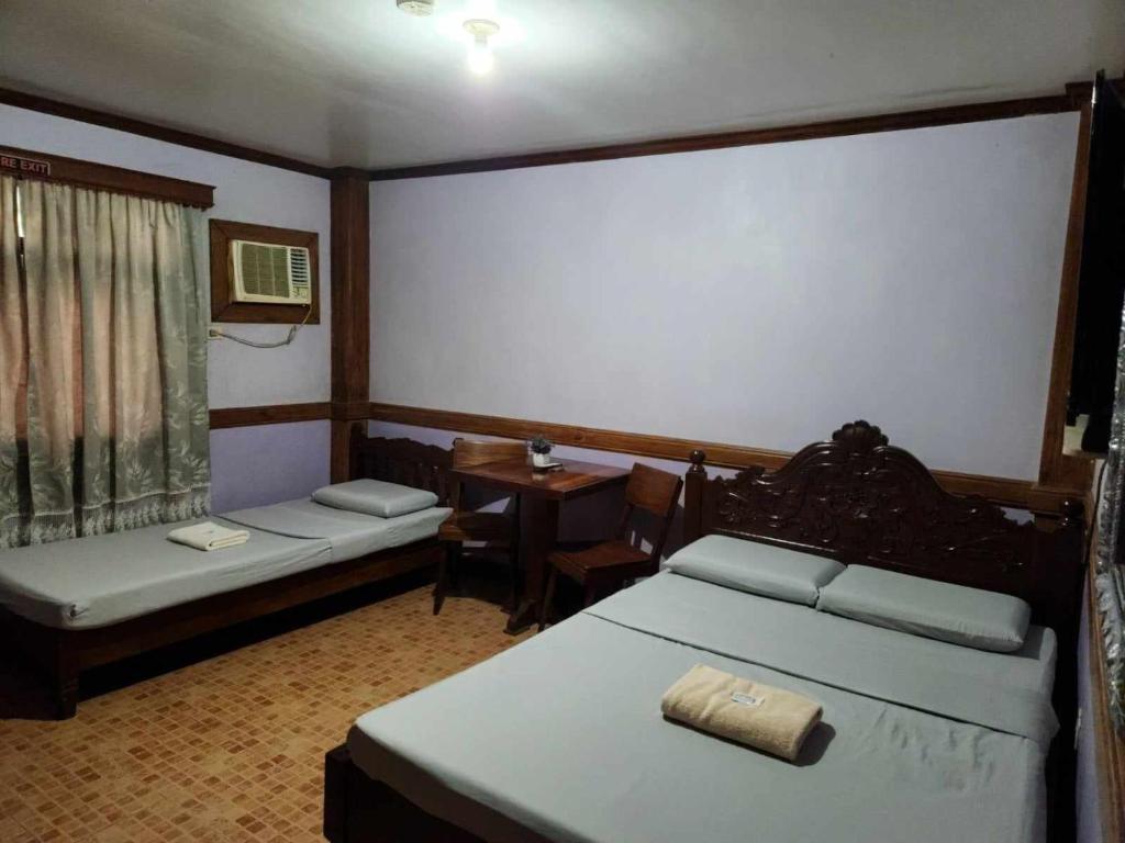 Habitación con 2 camas, mesa y escritorio. en Family Room in Bato, Camarines Sur 