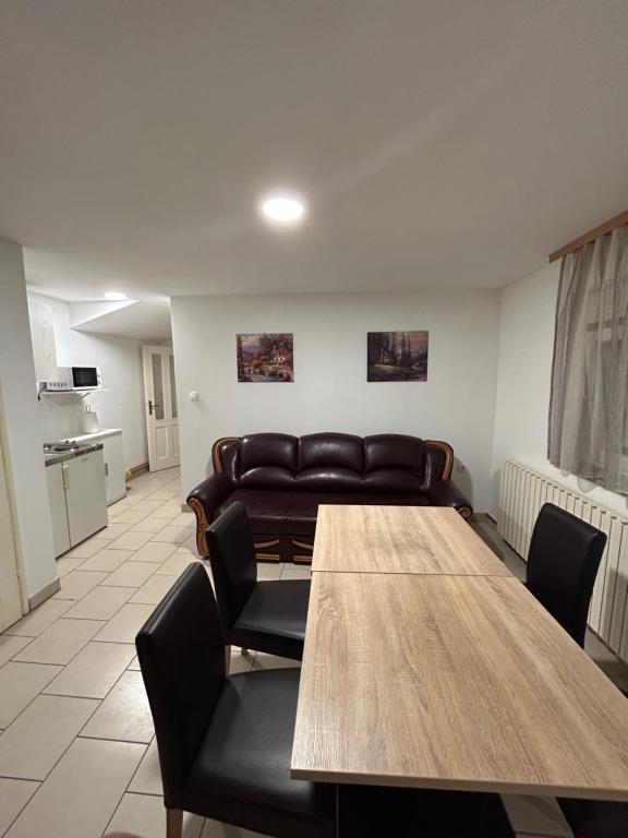 uma sala de estar com uma mesa e um sofá em Apartman Vanja em Pozega