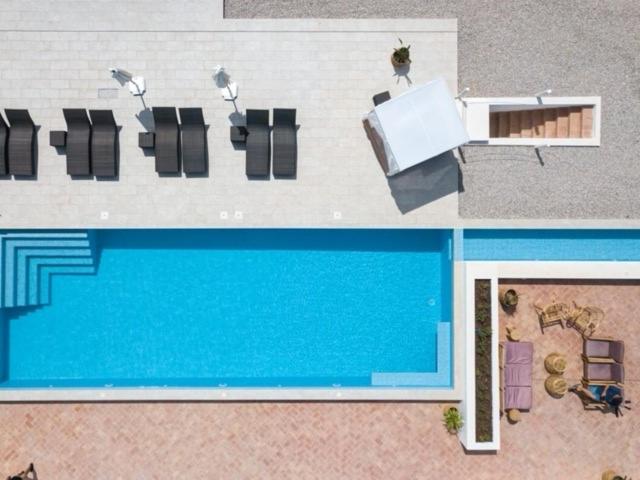 uitzicht op een zwembad met stoelen en een tafel bij Quinta do Ourives in Carvoeiro