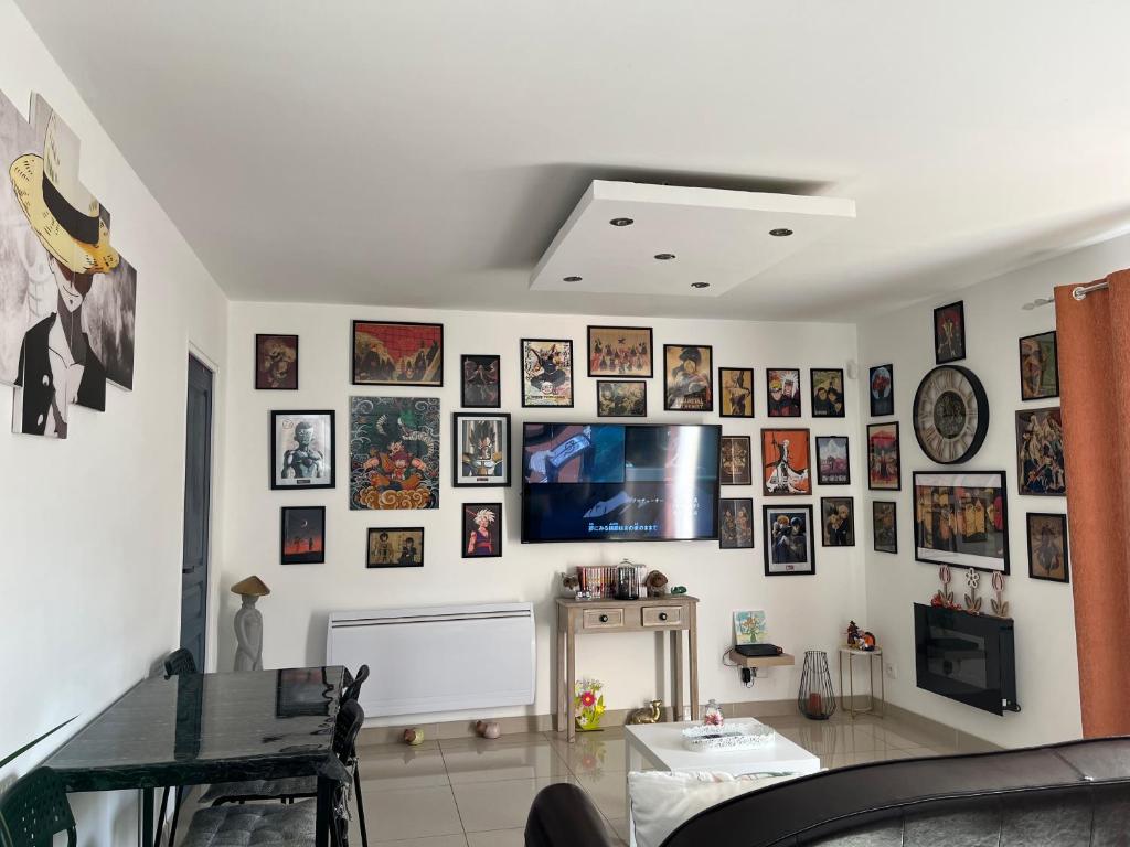 ein Wohnzimmer mit einer Wand mit Bildern an der Wand in der Unterkunft maison entre Disneyland et Paris in Meaux