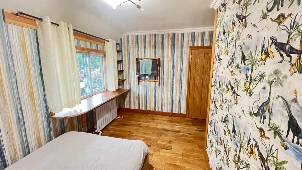 1 dormitorio con 1 cama y una pared con una pintura en Happy staying, en Wythenshawe