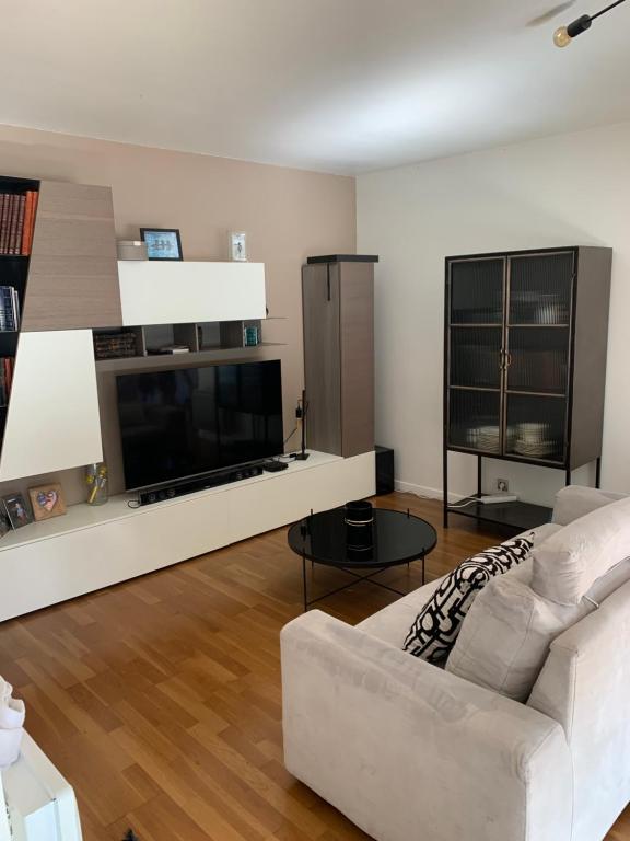 a living room with a white couch and a tv at Penthouse avec jacuzzi in Asnières-sur-Seine