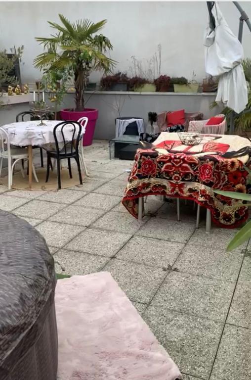 a patio with two tables and chairs on a patio at Penthouse avec jacuzzi in Asnières-sur-Seine