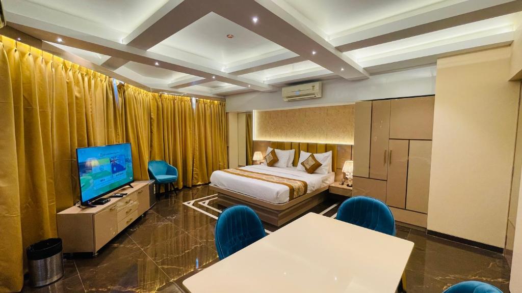 Una habitación de hotel con una cama y un televisor de pantalla plana. en Home2 Renaissance Club, en Bombay