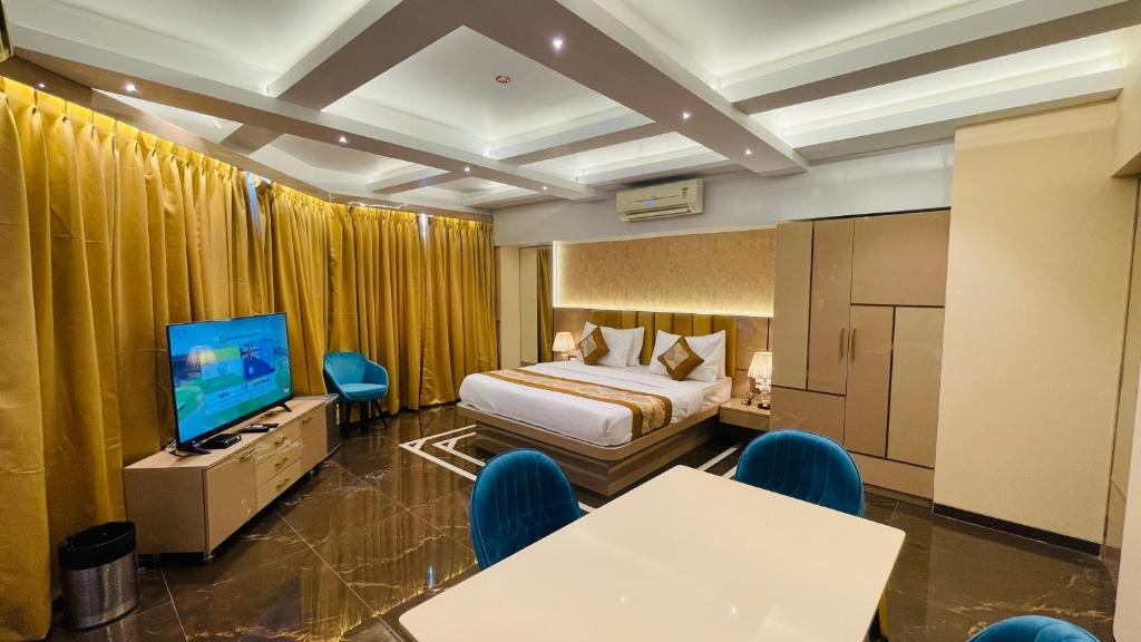 a hotel room with a bed and a flat screen tv at Home2 Renaissance Club in Mumbai