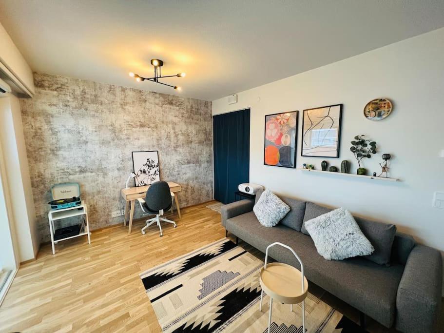 a living room with a couch and a table at Brand new modern condo built-in Mall of Tripla in Helsinki