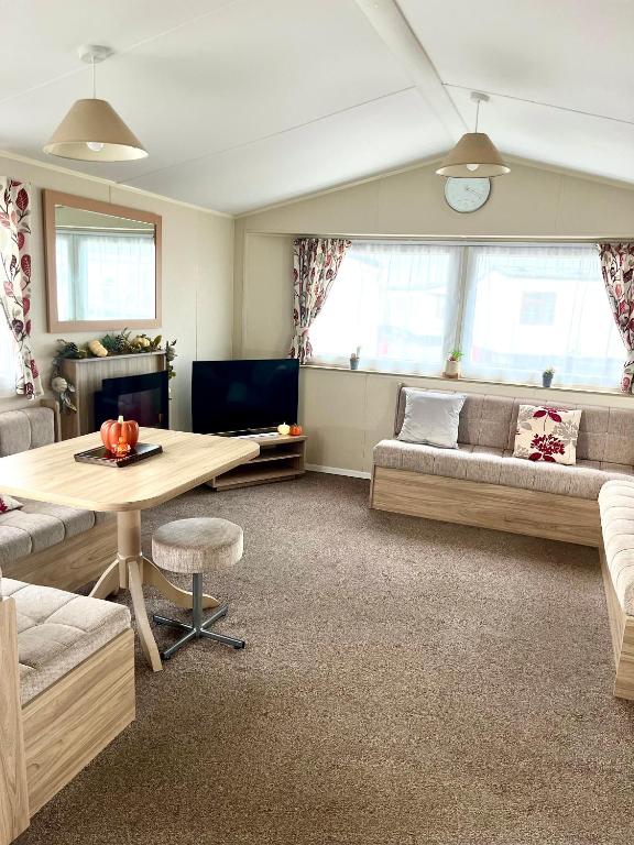 a living room with a couch and a table at 6 Birth Caravan Ingoldmels in Ingoldmells