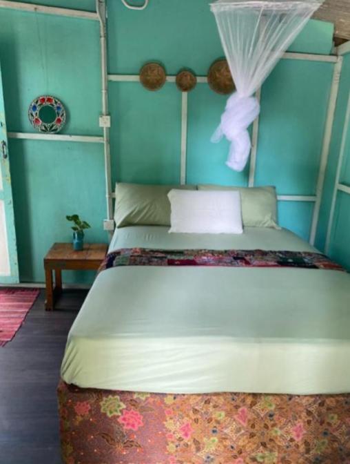 ein Schlafzimmer mit einem großen Bett mit blauen Wänden in der Unterkunft Eco Jungle Lodge Juara Tioman in Tioman Island