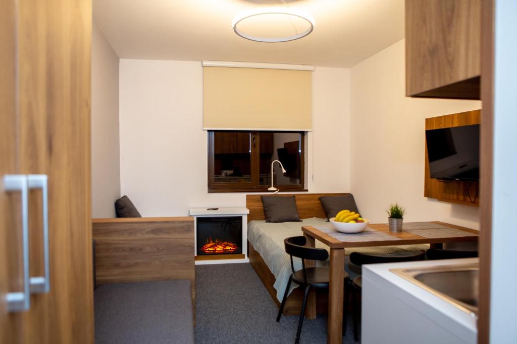 Habitación con cama y escritorio con chimenea. en Ramonda apartman vila Bela Reka 50m from Gondola - free parking acces, en Brzeće