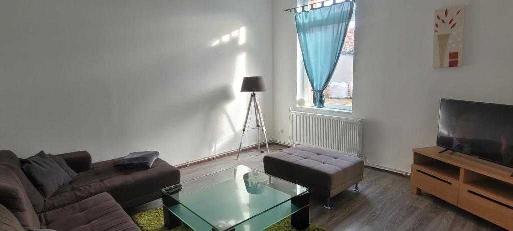 ein Wohnzimmer mit einem Sofa, einem Tisch und einem TV in der Unterkunft Ap 10 - 2 SZ bei Helmstedt und Oschersleben in Ausleben