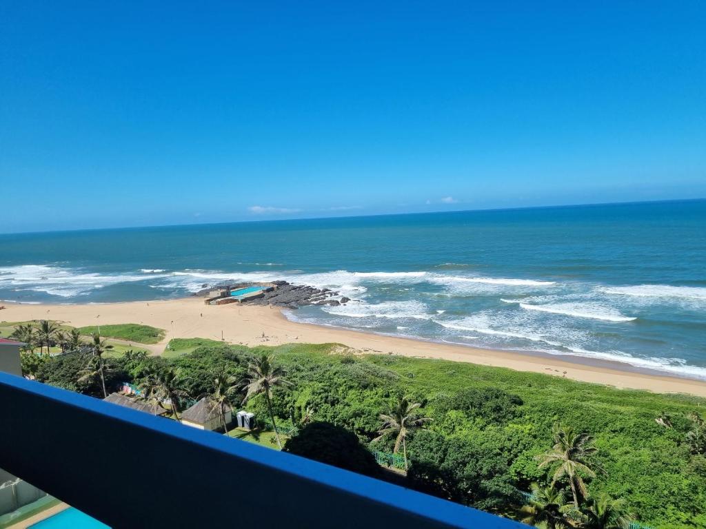 a view of the beach from the balcony of a resort at Stella Maris 117 Amanzimtoti in Amanzimtoti