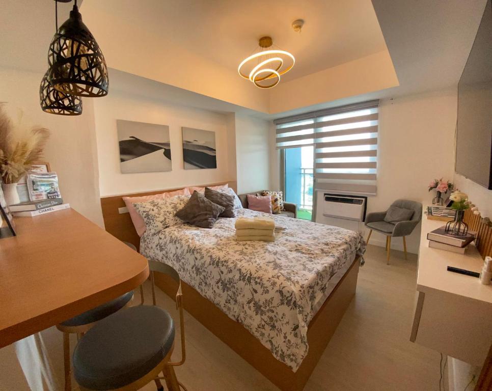 1 dormitorio con 1 cama, mesa y sillas en LeisureStay Studio @ Azure North en San Fernando