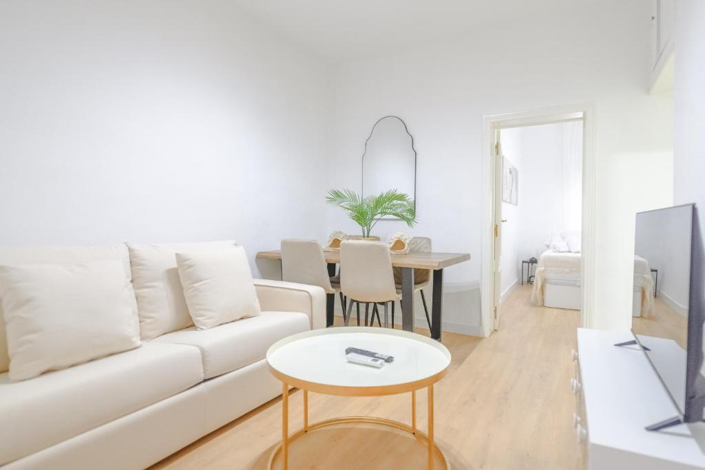 a living room with a white couch and a table at For You Rentals Bonito y coqueto apartamento en Vallecas CAU231D in Madrid