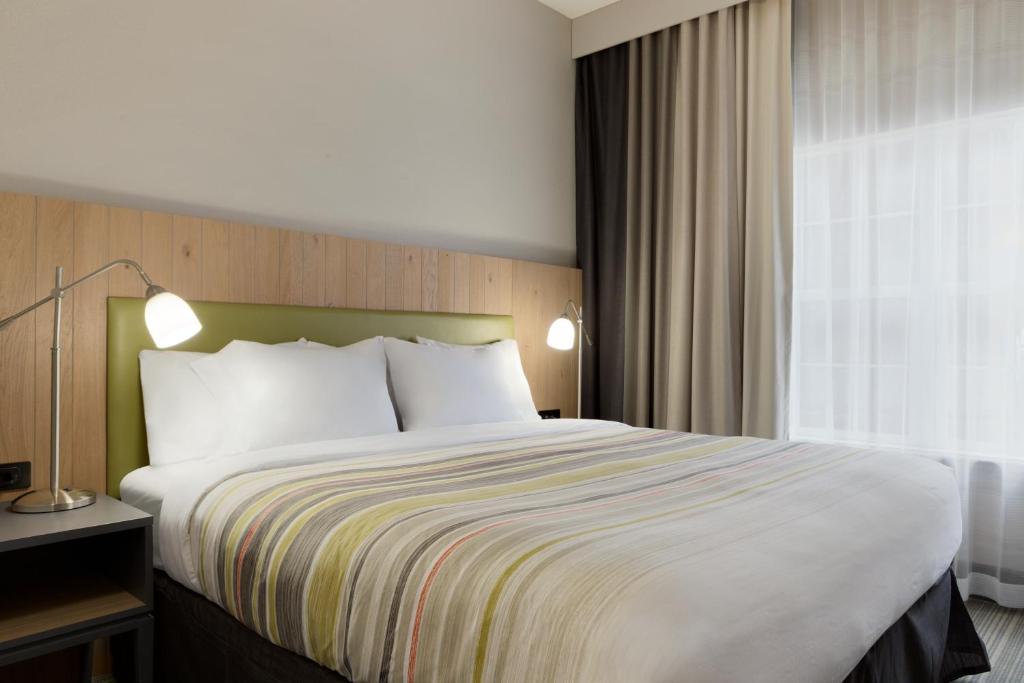 a hotel room with a large bed and a window at Country Inn & Suites by Radisson, Jackson, TN in Jackson