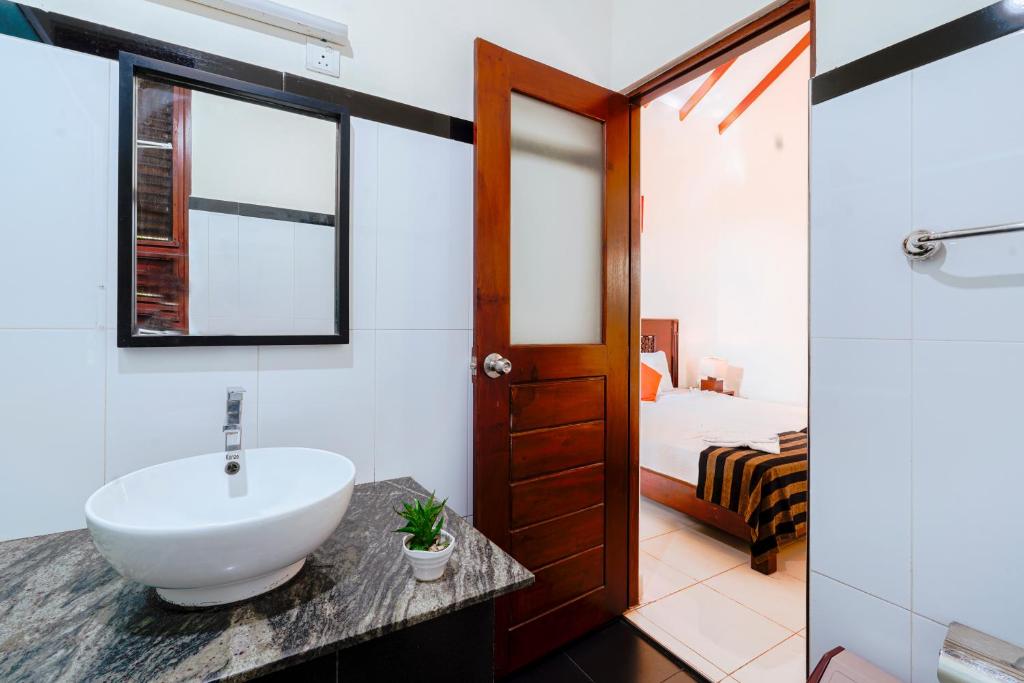 a bathroom with a sink and a bedroom at Safari Lodge Yala in Kataragama