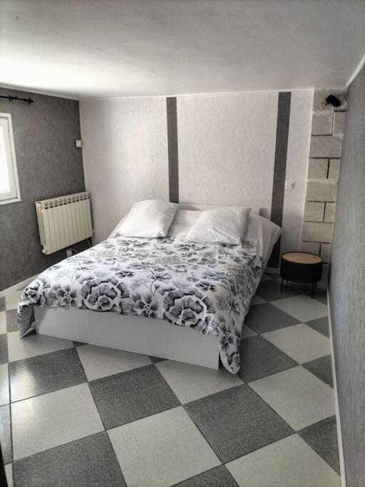 a bedroom with a bed and a checkered floor at Charmant appart avec extérieur in Aigues-Mortes