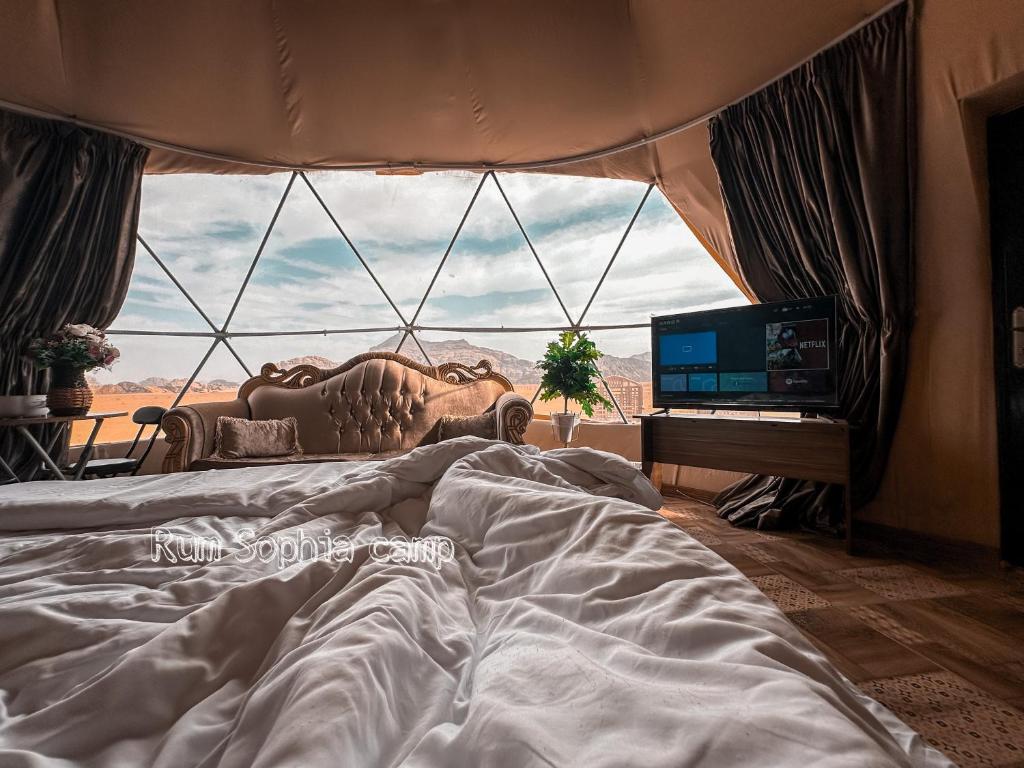 a bedroom with a bed and a large window at Rum Sophia camp in Wadi Rum