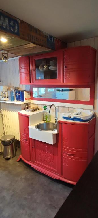 una cucina con armadi rossi e lavandino di Chambre privée bien desservie par les transports en commun a Colombes
