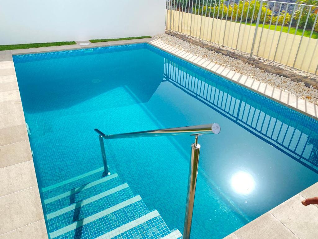 Una piscina azul con escaleras. en OH LA LIFE! MAGNOLIA GOLF SUSANA, en Adeje
