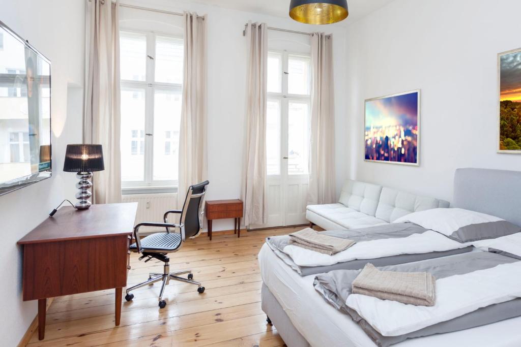 ein weißes Schlafzimmer mit einem Schreibtisch, einem Bett und einem Schreibtisch in der Unterkunft Brüsseler Straße 39 in Berlin