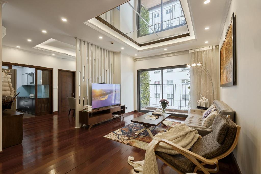 ein Wohnzimmer mit einem Sofa und einem TV in der Unterkunft Hanoi Premium 160 Sqm Apt with Top-Quality Furnishing in Hanoi