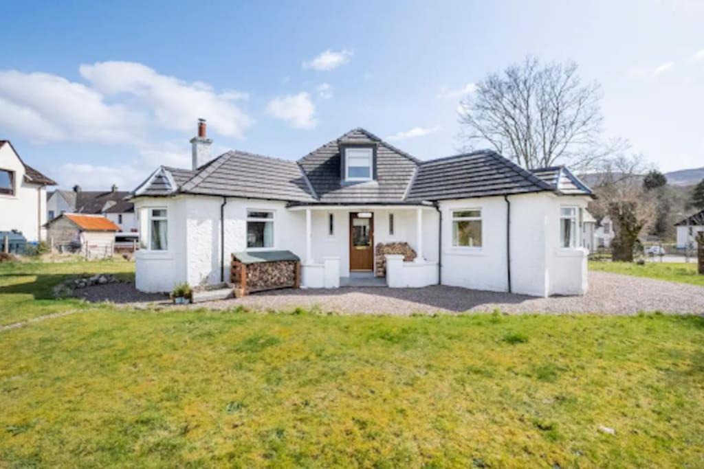 a white house with a large yard at Cosy Hygge/ Scottish themed home by Loch Ness in Fort Augustus