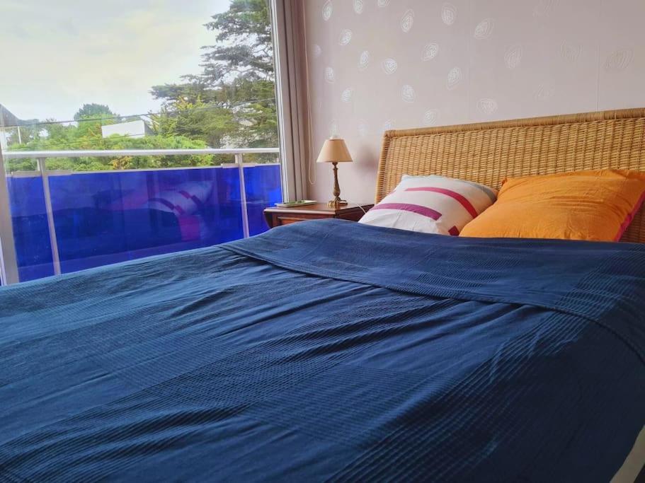 une chambre avec un lit bleu et une fenêtre dans l'établissement Family appartment 200 meters from the beach, à La Baule